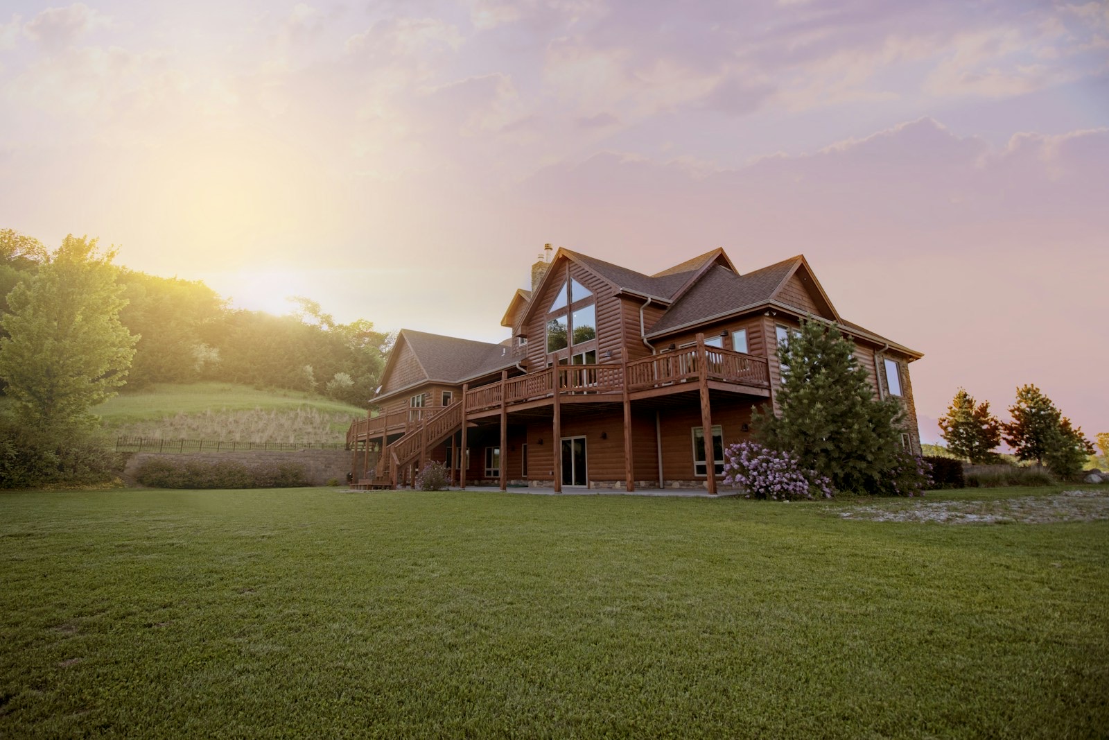 Timber frame Hudson Valley home at dusk — the type of roofline we run